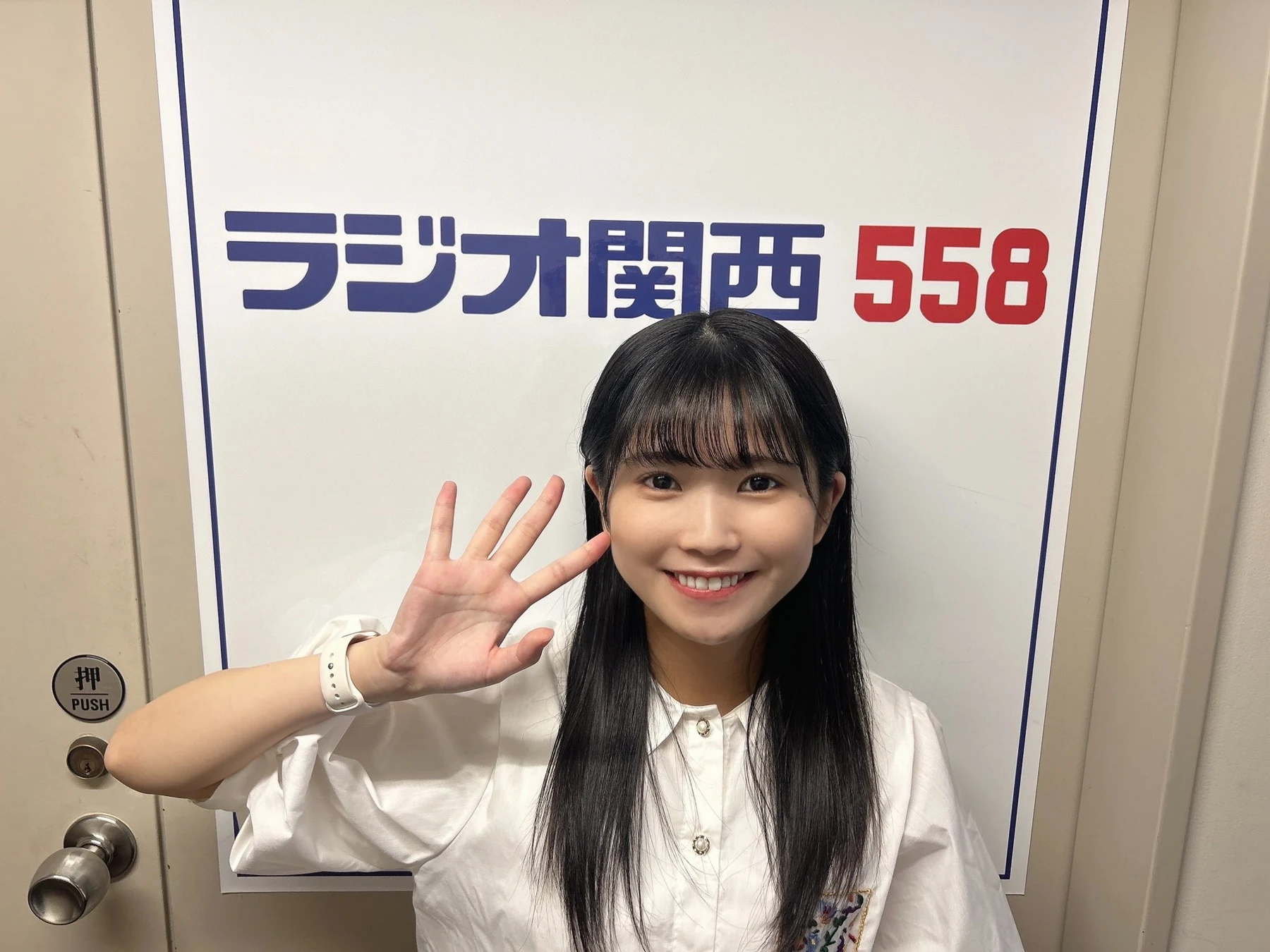 节目完结后，西条和在 Radio Kansai 558 标牌前微笑挥手。